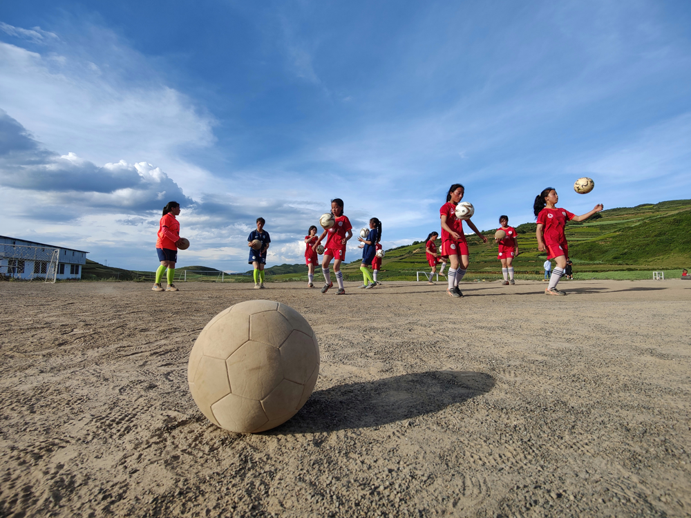 瓦吾小学女足球员在土地上训练